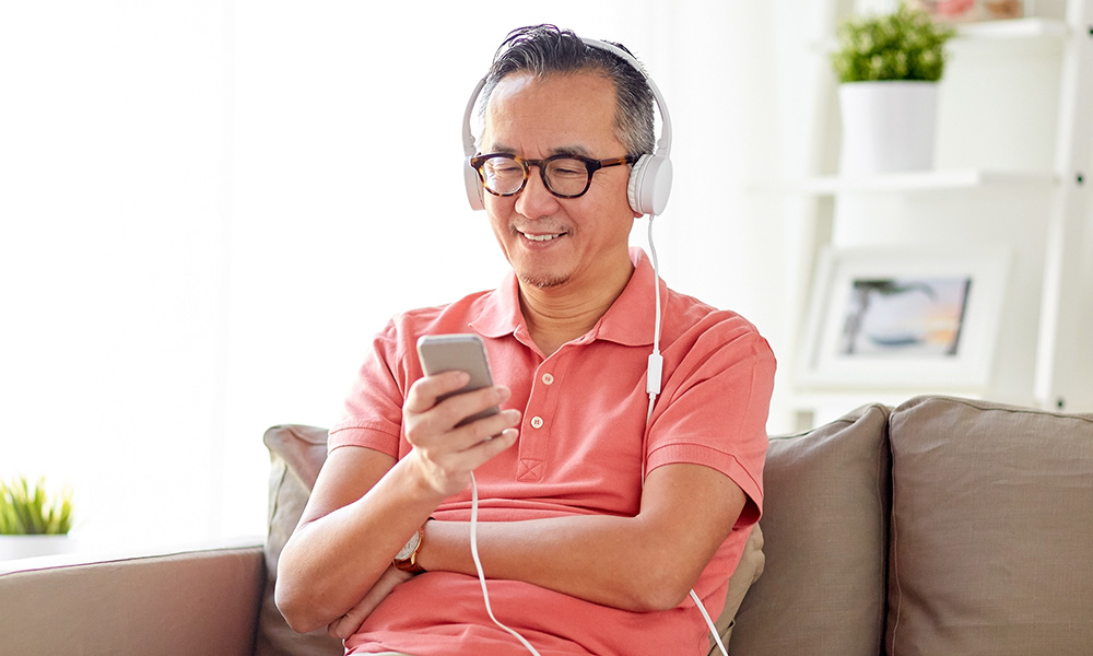 Man using smartphone to listen to a podcast